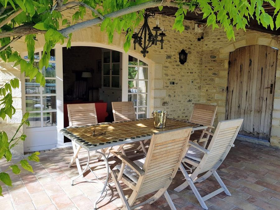 Table dressée sous la pergola en pierre